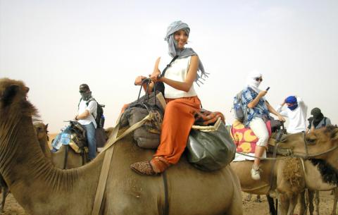 Link to GEO Regional Scholarships. Image description: A young woman riding a camel.