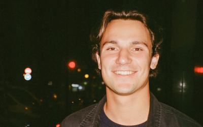 A young man stands by the city skyline