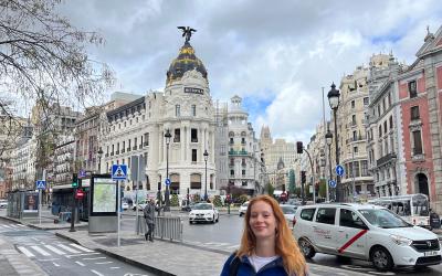 A young woman stands in a city square